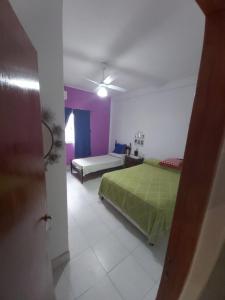 a bedroom with a green bed and purple walls at Casa en los Valles in Cafayate