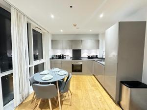 a kitchen with a table and chairs in a room at Luxury 2 Bedroom Penthouse Near Central London in London