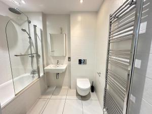 uma casa de banho com um WC, um lavatório e um chuveiro em Luxury 2 Bedroom Penthouse Near Central London em Londres