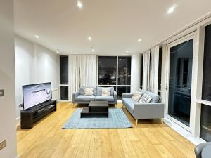 a living room with a couch and a flat screen tv at Luxury 2 Bedroom Penthouse Near Central London in London