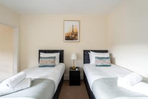 two beds sitting next to each other in a bedroom at Edgehill City Centre Haven By Icon Living Properties Short Lets & Serviced Accommodation Reading in Reading