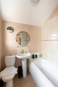 a bathroom with a sink and a tub and a toilet at Edgehill City Centre Haven By Icon Living Properties Short Lets & Serviced Accommodation Reading in Reading