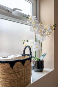 a basket and flowers on a window sill at Edgehill City Centre Haven By Icon Living Properties Short Lets & Serviced Accommodation Reading in Reading