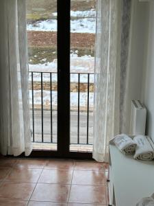 d'une chambre avec une porte coulissante en verre neige à l'extérieur. dans l'établissement Casa ELENA i MARTA , Valdelinares, à Valdelinares