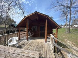 una terraza de madera con una cabina con una silla. en Secluded Rustic Cabin with Views, en Bloomington