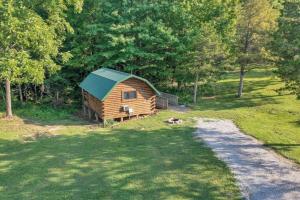 a wooden cabin with a green roof in a field at Rustic Cabin with Pool Access in Bloomington