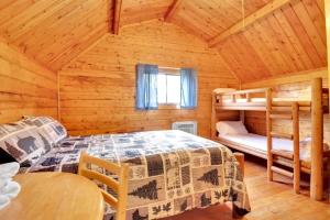 布卢明顿Rustic Cabin with Pool Access的小屋内设有一间带两张双层床的卧室 更多37张照片