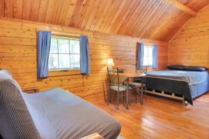 een slaapkamer met 2 bedden en een tafel in een hut bij Cozy Rustic Cabin with Views in Bloomington