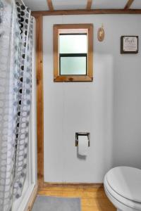 baño con aseo y ventana en Charming Log Cabin in Bloomington, en Bloomington