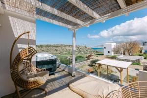 a balcony with a swing and a view of the ocean at Villa Blue Zircon in Stelida