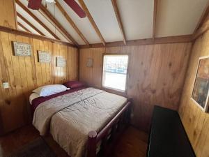 1 dormitorio con 1 cama en una habitación de madera en Relaxing Cabin in Bloomington, en Bloomington