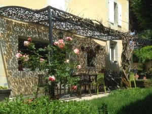 eine Pergola mit Rosen an der Seite eines Hauses in der Unterkunft Maison chez nous in Izeron