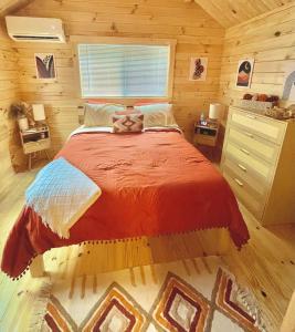 a bedroom with a bed in a log cabin at Charming Cabin near Ark Encounter with Loft in Dry Ridge