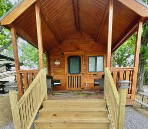 Cabaña de madera con escalera que conduce a un porche en Charming Cabin near Ark Encounter with Loft en Dry Ridge