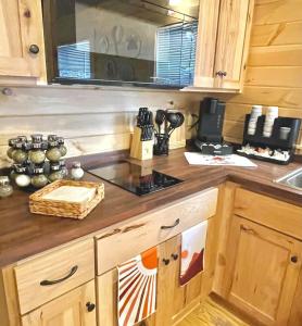 a kitchen with wooden cabinets and a stove top oven at Charming Cabin near Ark Encounter with Loft in Dry Ridge