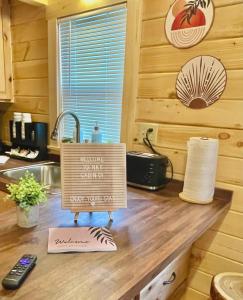 a sign on top of a counter in a kitchen at Charming Cabin near Ark Encounter with Loft in Dry Ridge