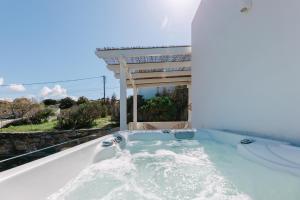 a jacuzzi tub with a pergola at Villa Blue Zircon in Stelida