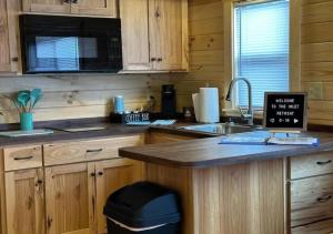 eine Küche mit einer Theke mit einer Spüle und einer Mikrowelle in der Unterkunft Get-away Cabin in Surf City w Loft and Parking in Surf City