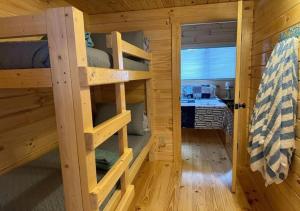 Zimmer mit Etagenbetten in einem Blockhaus in der Unterkunft Get-away Cabin in Surf City w Loft and Parking in Surf City