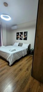 een slaapkamer met een groot wit bed in een kamer bij @Bazaar2 in Tirana