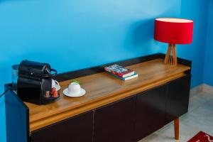 a table with a red lamp and books on it at Estúdio frente mar de Copacabana WIFI 500M in Rio de Janeiro