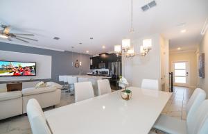 a kitchen and living room with a white table and chairs at Luxury Townhouses 18 Minutes away from Disney! in Kissimmee