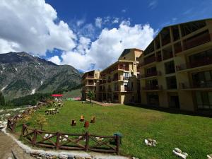 a building with a grass field in front of a building at The Sarai, Naran in Naran