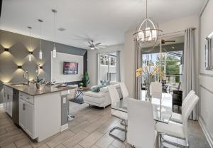a kitchen and living room with white chairs and a table at Luxury Townhouses 18 Minutes away from Disney! in Kissimmee
