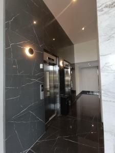een lobby met een zwarte marmeren muur en een lift bij Torres Brickell. in Tigre