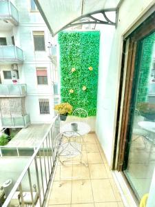 a balcony with a table and chairs and a green wall at B&B station in Brindisi