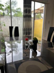 une table en verre avec deux vases au-dessus dans l'établissement Dulce Hogar 01, à Loja