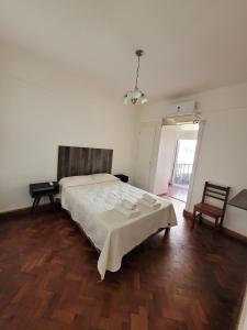 1 dormitorio con 1 cama y suelo de madera en La Belgrano en Salta