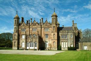 un antico castello con un prato verde davanti di Walnut Apartment Larne a Larne