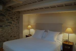 a bedroom with a large white bed with two lamps at Mas Vermell in Fontanilles