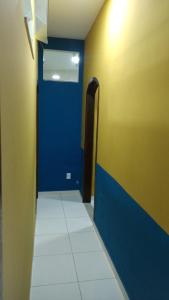 a hallway with a blue door in a room at Pousada Mundo Novo in Aparecida