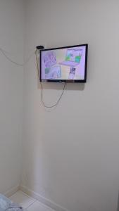 a flat screen tv hanging on a white wall at Pousada Mundo Novo in Aparecida