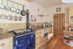 a kitchen with a blue stove and a table at 17th Century Rural Home in Hawthorn