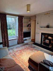 sala de estar con sofá y chimenea en 17th Century Rural Home en Hawthorn