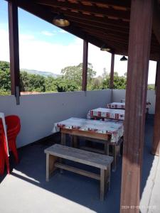 two tables and a bench on a patio at Pousada Mundo Novo in Aparecida