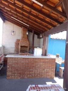 an outdoor kitchen with a brick pizza oven at Pousada Mundo Novo in Aparecida