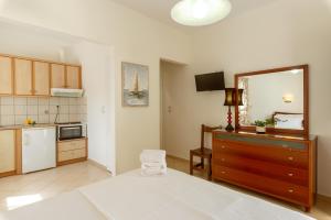 a bedroom with a large bed and a kitchen at Angela Studios in Syvota
