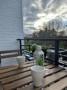 ein Holztisch mit zwei Tassen auf einem Balkon in der Unterkunft Apartamento Pura Vida in Córdoba