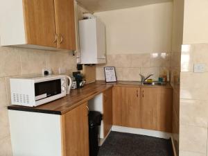 a kitchen with a microwave on a wooden counter at Ideal Apartment close to the Hustle and Bustle in Ashton under Lyne