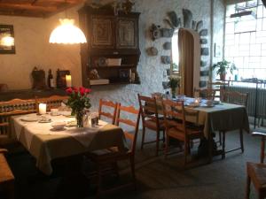 a dining room with two tables and chairs with flowers on them at Pension Silberdistel in Ühlingen-Birkendorf