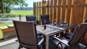 una mesa de madera con 2 botellas de vino en el patio en Ferienwohnung-Wipperau-I, en Uelzen