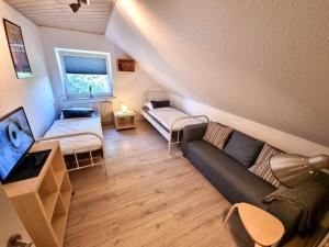 sala de estar con sofá y TV en Ferienwohnung-Wipperau-I, en Uelzen