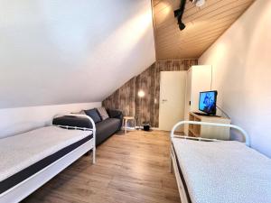 Habitación pequeña con 2 camas y sofá en Ferienwohnung-Wipperau-I, en Uelzen