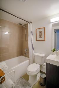 a bathroom with a toilet and a tub and a sink at Brand New Studio in Heart of Downtown Toronto J8 in Toronto