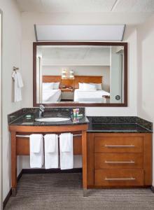 a bathroom with a sink and a large mirror at Hyatt Place Dallas/Plano in Plano