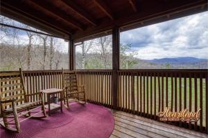 a screened in porch with two chairs and a table at Top of the World 2 Bedroom 2 Bath Cabin between Pigeon Forge and Gatlinburg in Pigeon Forge